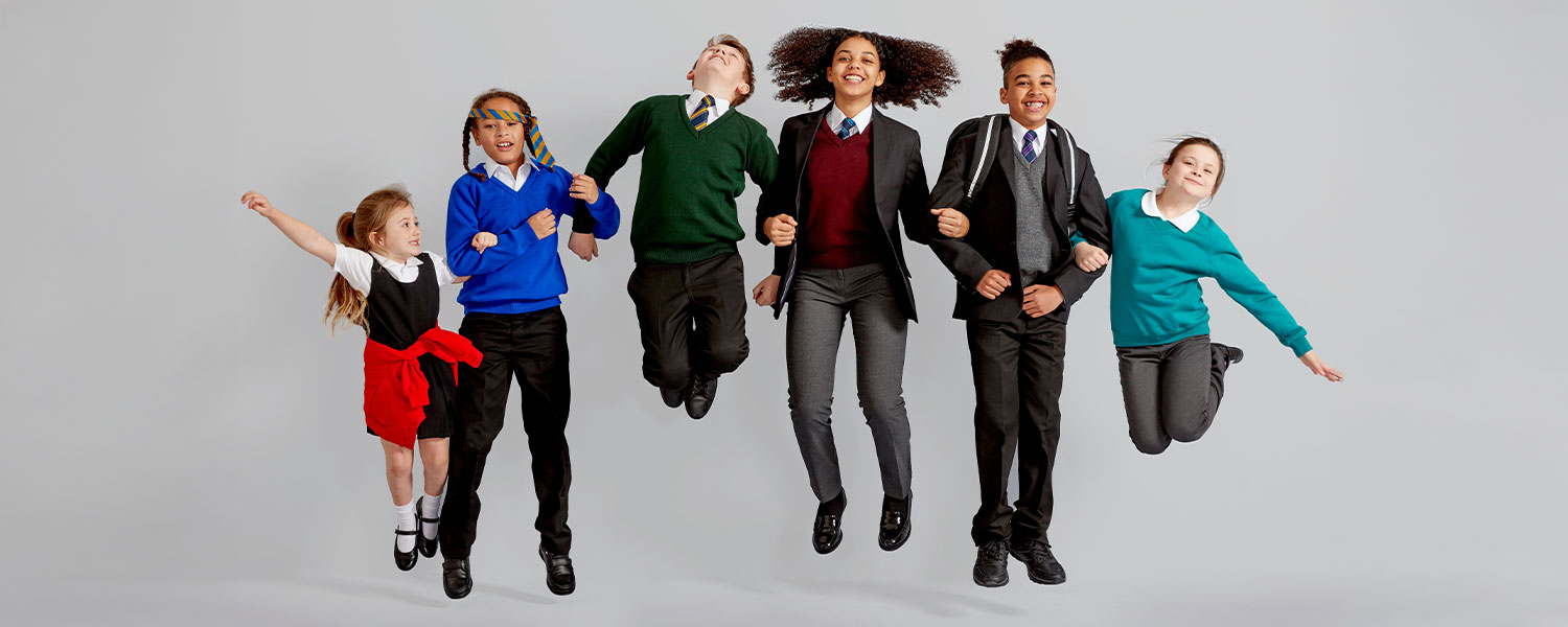 students in uniform jumping together